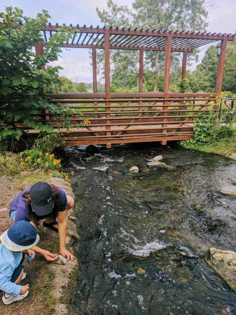 Mom and her son standing next to water